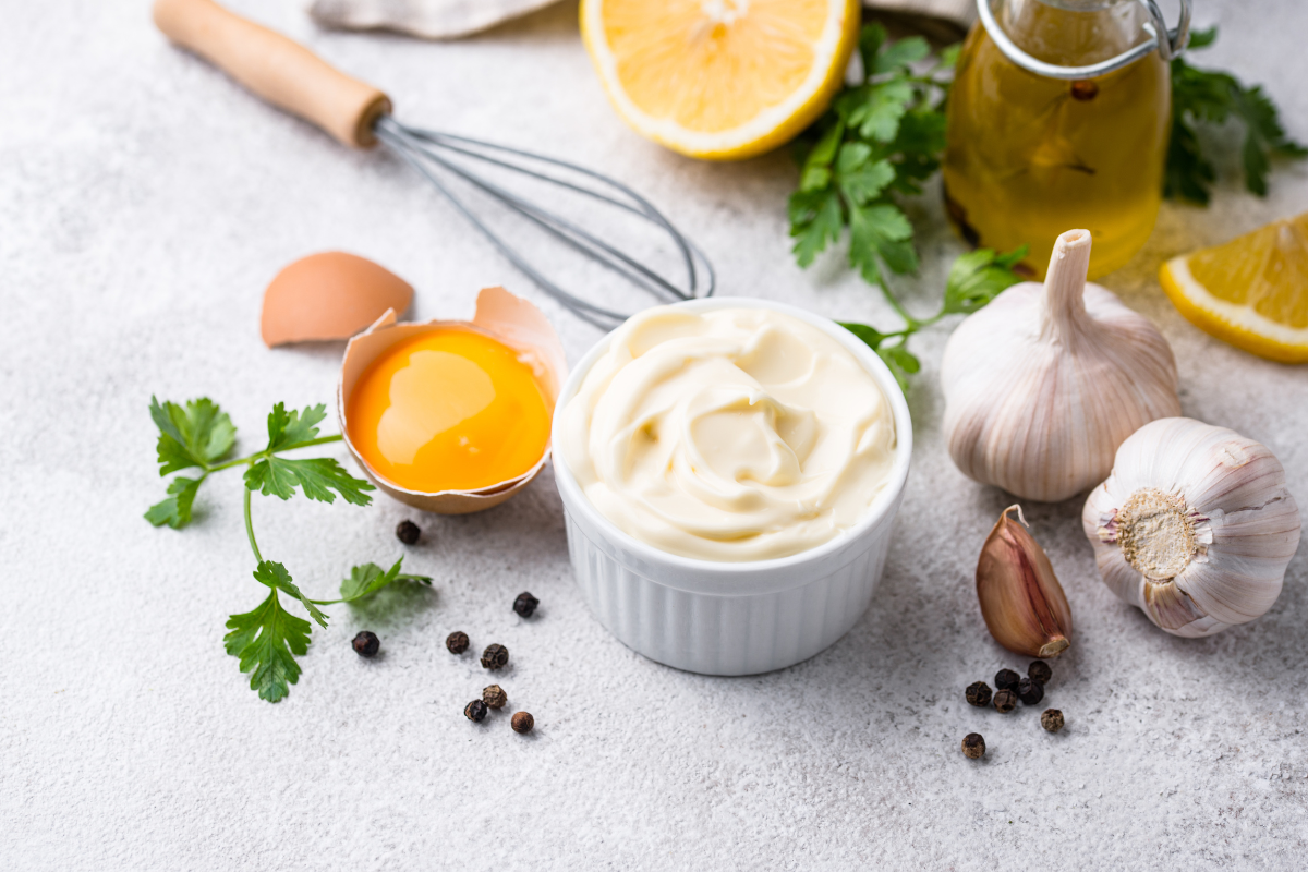 Bowl with mayonnaise and ingredients for cooking